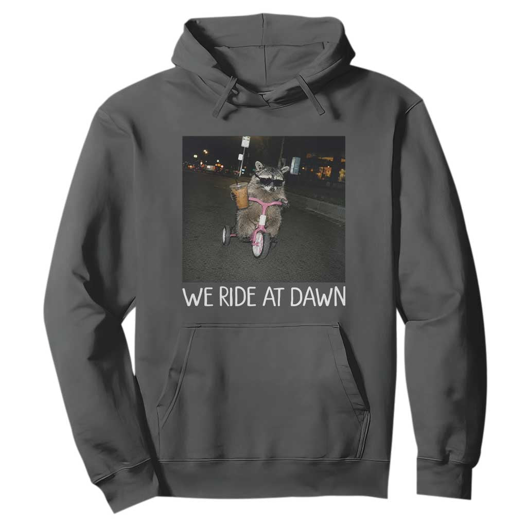 We Ride at Dawn Hoodie Funny Racoon Riding Tricycle Chaotic Meme TS14 Dark Heather Print Your Wear