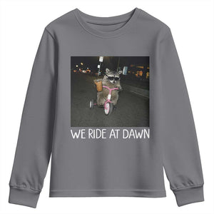 We Ride at Dawn Youth Sweatshirt Funny Racoon Riding Tricycle Chaotic Meme TS14 Charcoal Print Your Wear